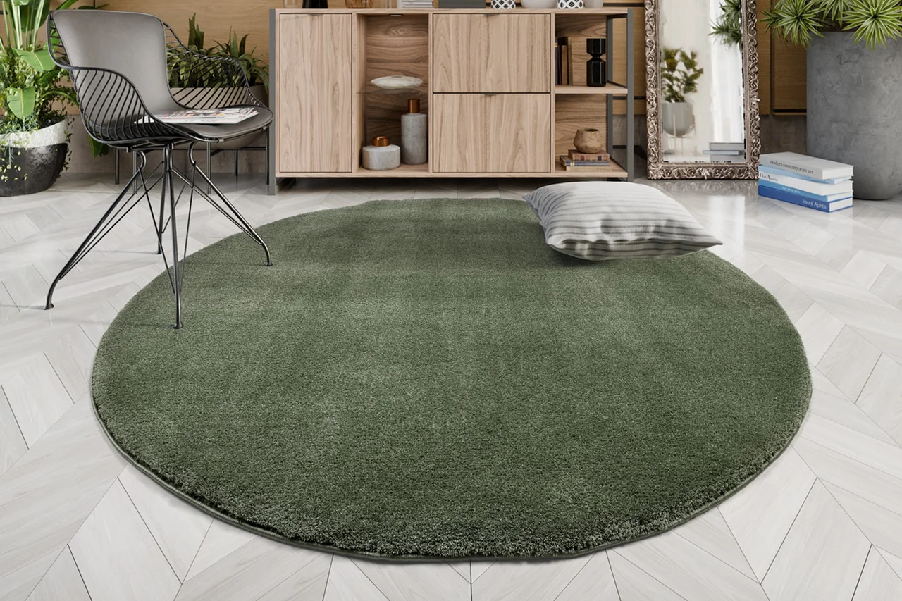Ein runder grüner Hochflor Teppich liegt im Wohnzimmer - Ein runder grüner Hochflor Teppich liegt im Wohnzimmer