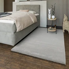 Ein Hochflor Teppich liegt im Schlafzimmer neben dem Bett - Ein Hochflor Teppich liegt im Schlafzimmer neben dem Bett